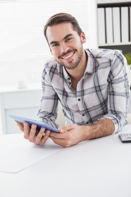 Hombre de negocios casual con tableta en el escritorio