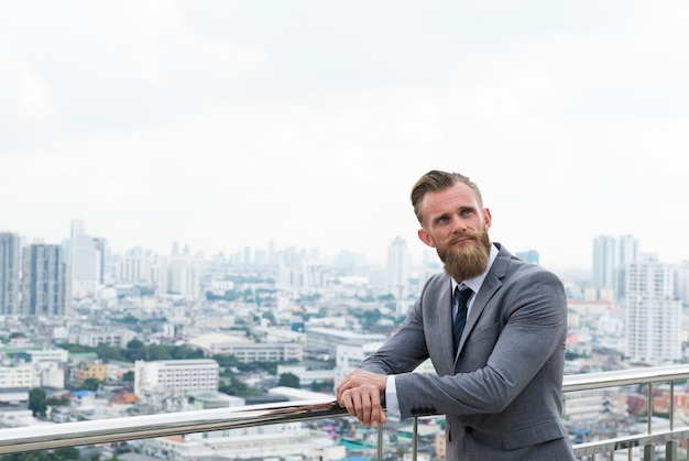 Hombre de negocios caucásico barandillas de pie vista de la ciudad