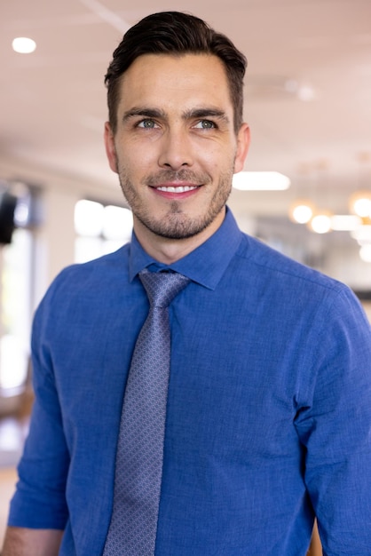 Foto un hombre de negocios caucásico feliz con una camisa azul en una oficina moderna. negocios globales, finanzas y concepto de oficina.