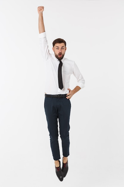 Hombre de negocios caucásico feliz joven que salta en el aire, aislado en blanco.