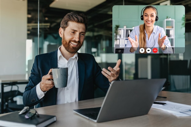 Foto hombre de negocios caucásico guapo y positivo hablando con socios de negocios a través de la computadora portátil