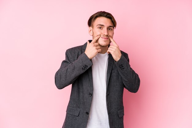 Hombre de negocios caucásico joven posando aislado dudando entre dos opciones.