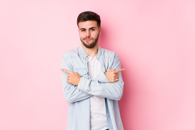 Foto hombre de negocios caucásico joven posando en un blanco puntos aislados hacia los lados