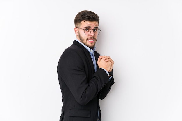 Hombre de negocios caucásico joven posando en una pared blanca aislada Hombre de negocios caucásico joven asustado y asustado.