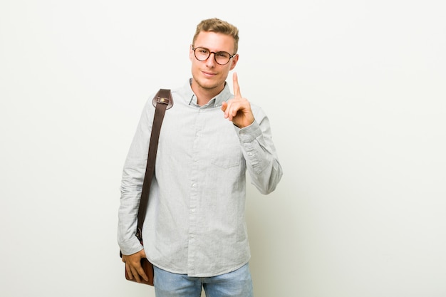 Hombre de negocios caucásico joven que muestra el número uno con el dedo.