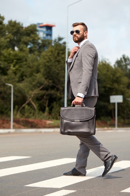 Hombre de negocios caucásico que viaja a la oficina llevando su bolso de oficina
