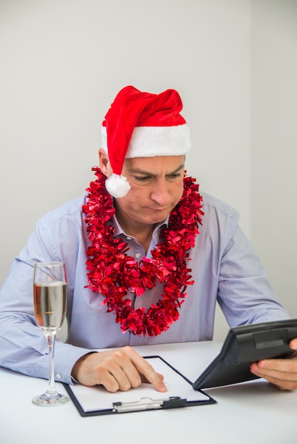 El Hombre De Negocios Celebra Feliz Navidad Y Feliz Año Nuevo Desgaste Santa Hat. Deprimido, hombre de negocios, tenencia, calculadora