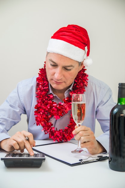 El Hombre De Negocios Celebra Feliz Navidad Y Feliz Año Nuevo Desgaste Santa Hat. Serio hombre de mente pensando en la manera de resolver sus problemas en la víspera de año nuevo