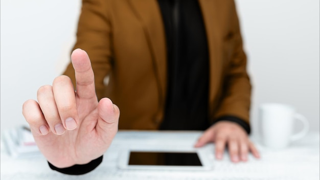 Hombre de negocios con chaqueta marrón sentado en la mesa y señalando con un dedo el mensaje importante Caballero mostrando un anuncio crítico Teléfono en la mesa