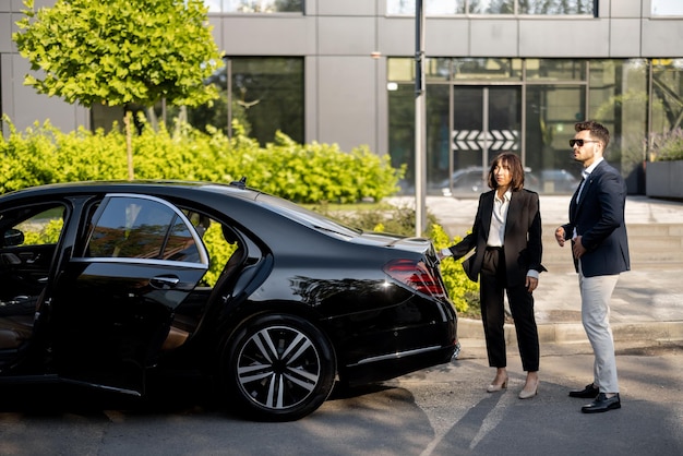 Hombre de negocios y chofer cerca del coche al aire libre