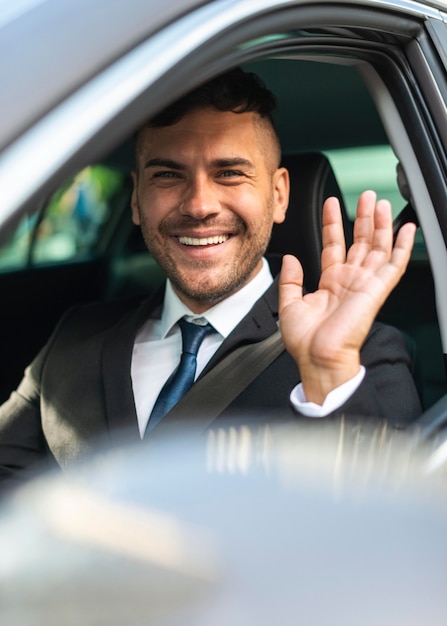 Foto hombre de negocios en el coche saludando