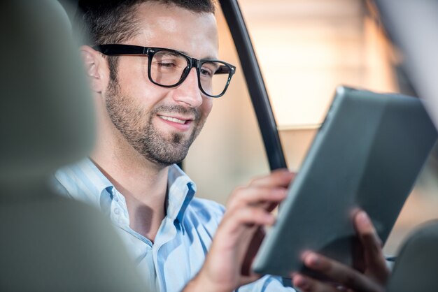 Hombre de negocios en coche con tableta