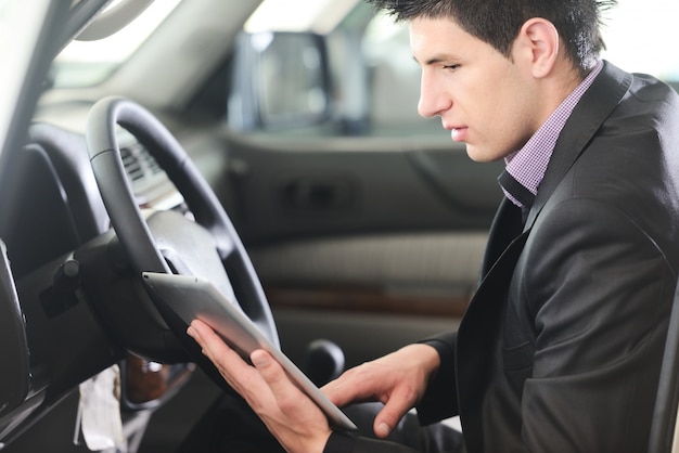 Hombre de negocios en el coche con la tableta