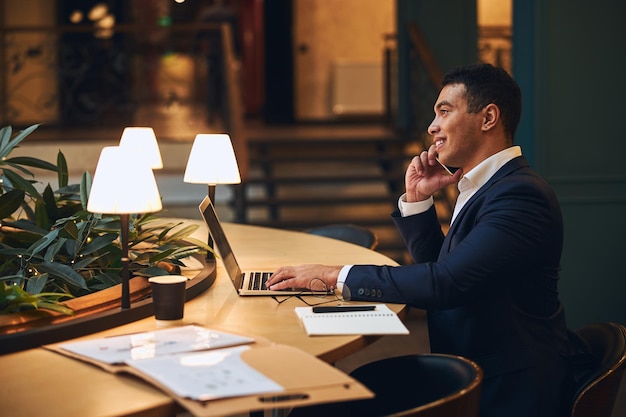 Hombre de negocios complacido teniendo una conversación por teléfono