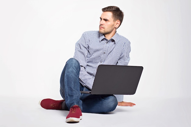 Hombre de negocios con una computadora portátil en un fondo blanco
