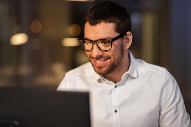 hombre de negocios con computadora trabajando en la oficina nocturna
