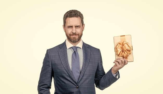 Hombre de negocios confiado sonriente en traje mantenga caja de regalo aislada en el día de los hombres blancos