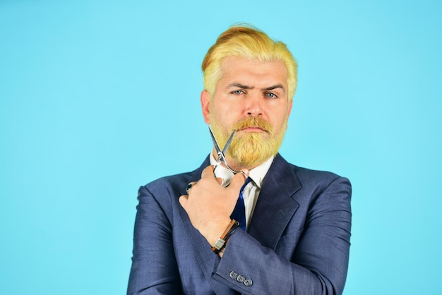 Hombre de negocios confiado sostiene herramientas de peluquería hombre maduro teñido de barba y peinado para una reunión formal belleza masculina e higiene personal peluquero profesional corte y afeitado barbería