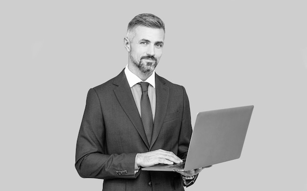 Hombre de negocios confiado en traje profesional escribiendo en la computadora portátil revisando el correo electrónico