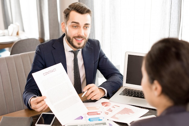 Hombre de negocios confidente que muestra el contrato al colega