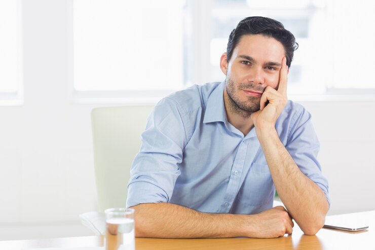 Foto hombre de negocios confidente que se sienta en el escritorio
