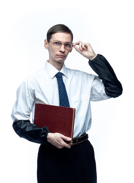 Un hombre de negocios con corbata y gafas con una revista en las manos sobre un fondo blanco aislado.