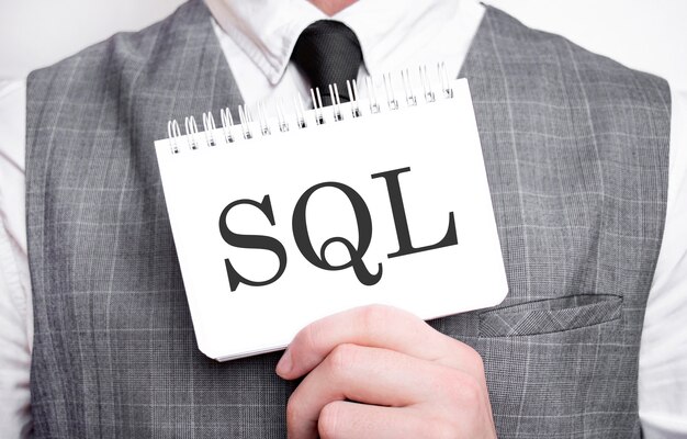 Hombre de negocios con cuaderno con texto SQL. Concepto de negocio