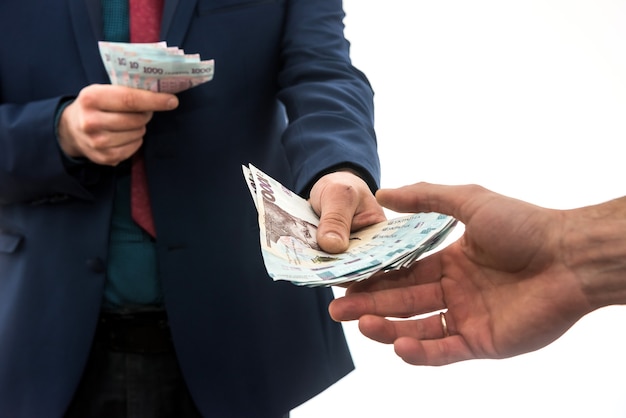 El hombre de negocios da o recibe un soborno de dinero. Hryvnia ucraniana, nuevos billetes de 1000 hryvnia. Guardar o concepto de corrupción.
