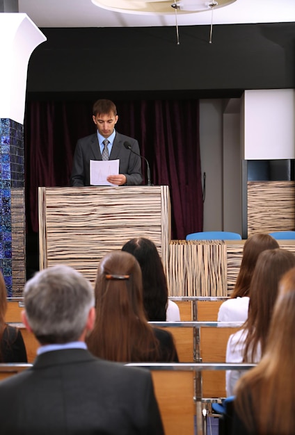 Foto el hombre de negocios está dando un discurso en la sala de conferencias