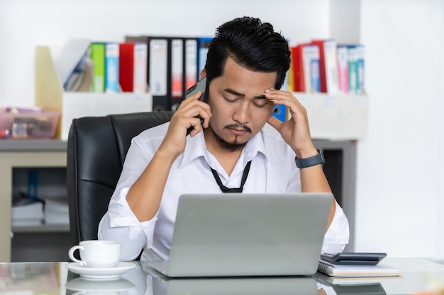 Hombre de negocios deprimido está hablando por teléfono inteligente