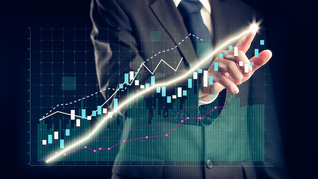 El hombre de negocios dibuja un gráfico alusivo a las finanzas que muestra el crecimiento de las ganancias comerciales