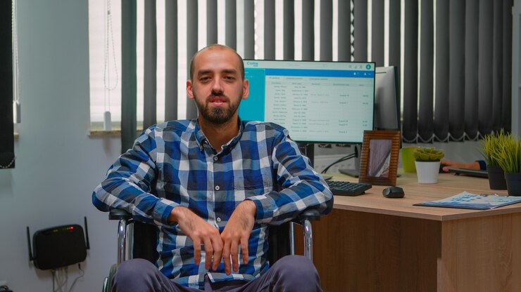 Foto hombre de negocios discapacitado discapacitado en silla de ruedas saludando en videollamada con conferencia en línea en la oficina de negocios. trabajador autónomo paralizado e inmovilizado que trabaja en una empresa financiera con tecnología moderna.