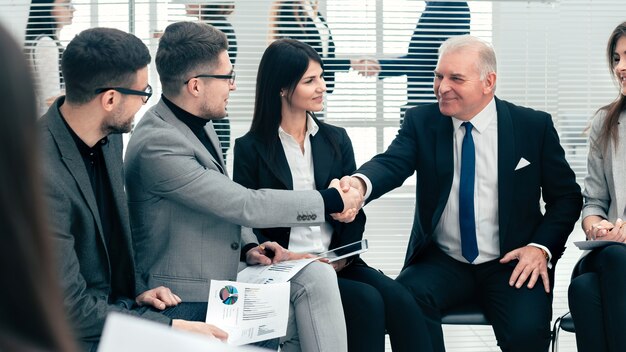 Hombre de negocios y empresaria estrecharme la mano en una sala de conferencias. concepto de negocio