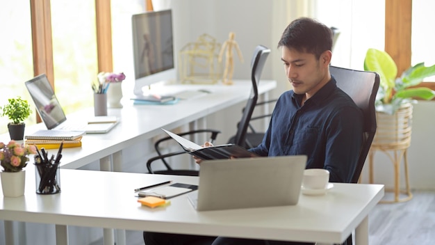 El hombre de negocios enfocado está trabajando en el lugar de trabajo de la oficina El jefe masculino está sentado en su habitación privada