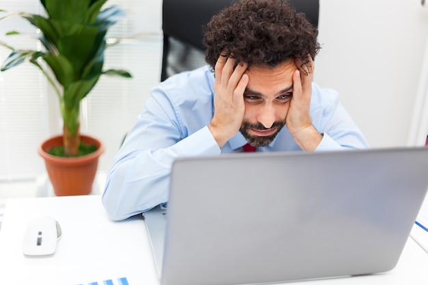 Hombre de negocios enojado mirando su computadora