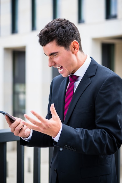 Hombre de negocios enojado con teléfono inteligente