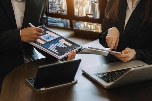 Foto hombre de negocios y equipo analizando estado financiero tarea financiera. con teléfono inteligente y computadora portátil y tableta. concepto de gestión patrimonial