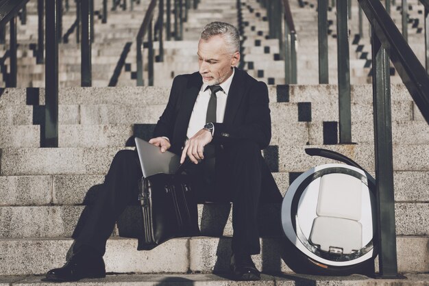 El hombre de negocios es Take Laptop from Briefcase