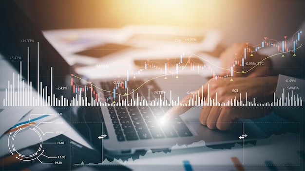 El hombre de negocios escribe a mano en la computadora portátil de las ganancias de la empresa con colegas, el socio explica con el cuadro de estadísticas del tablero virtual, gráficos infográficos de acciones, criptomoneda y nuevas plataformas comerciales