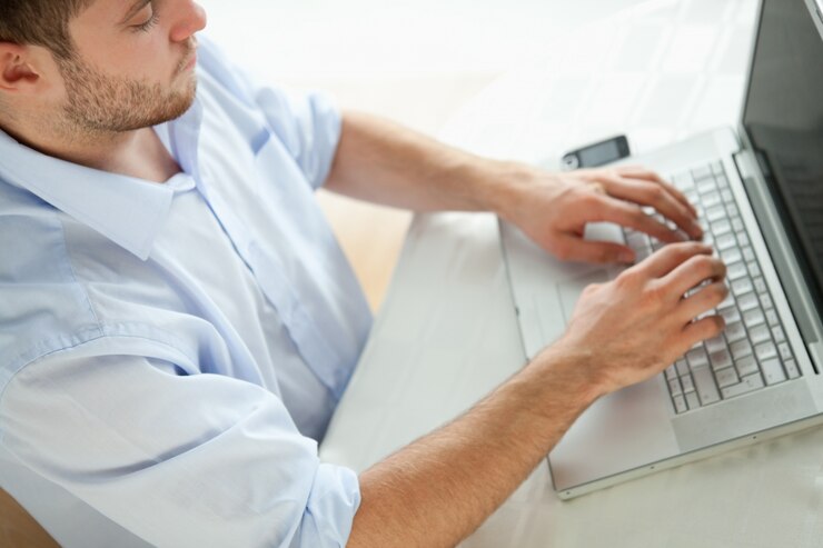 Foto un hombre de negocios escribiendo en una computadora portátil.