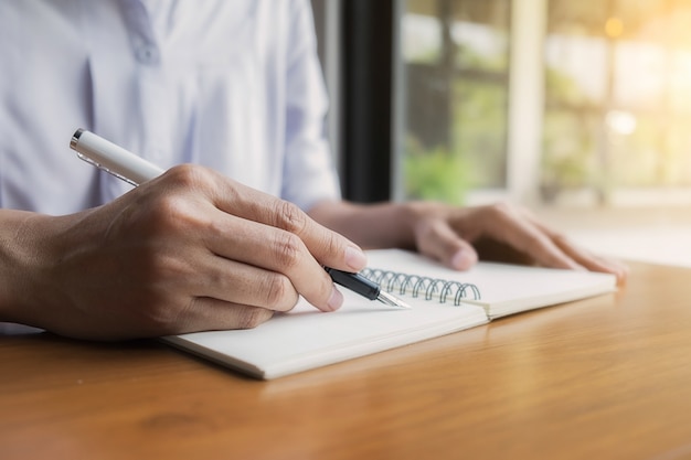 Hombre de negocios escribiendo sobre una libreta