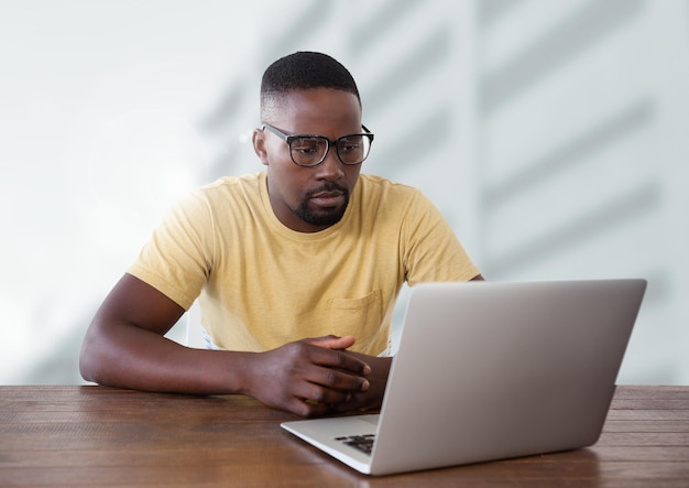 hombre de negocios, en el escritorio, con, computador portatil, con, brillante, plano de fondo