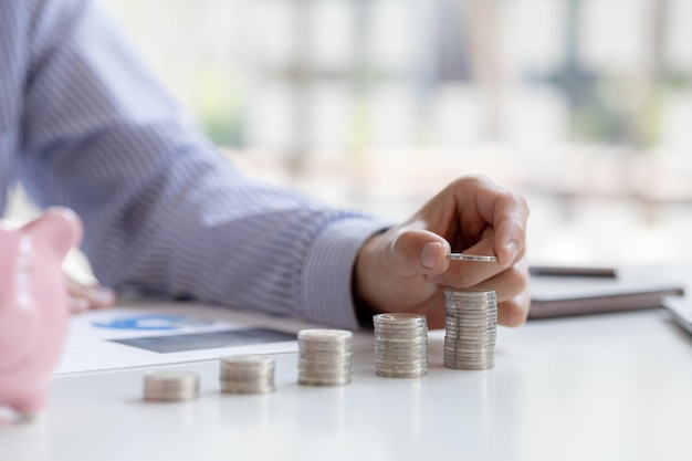 El hombre de negocios está apilando monedas encima de la pila de monedas en la fila más alta Colocar monedas en una fila de menor a mayor es comparable a ahorrar dinero para crecer más Ideas para ahorrar dinero para invertir en fondos