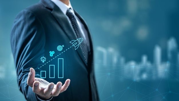 El hombre de negocios está mostrando un icono de un cohete volador a través de un gráfico en su mano Innovación tecnológica en una pantalla virtual Concepto de inicio de negocio