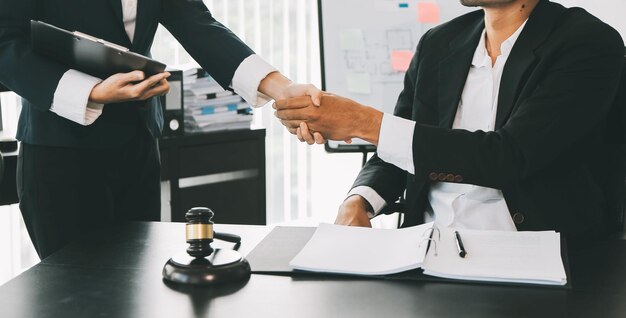 Foto hombre de negocios estrechando la mano para sellar un acuerdo con sus abogados o abogados socios discutiendo un acuerdo contractual