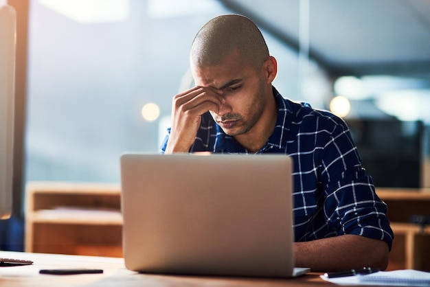 Hombre de negocios estresado y confundido en la computadora portátil en la oficina por noticias error o error con el proyecto de puesta en marcha diseñador gráfico cansado con fatiga dolor de cabeza o preocupación en el ordenador para la fecha límite en línea por la noche