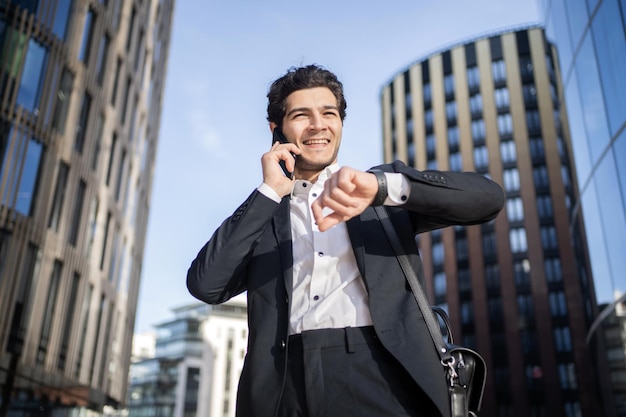 Un hombre de negocios exitoso se comunica con un colega que usa el teléfono para ir a la oficina