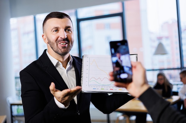 Un hombre de negocios exitoso está grabando un curso de seminario web sobre cómo trabajar con el comercio en el mercado de valores Lecciones en línea para negocios Desarrollo de un enfoque selectivo de blog personal