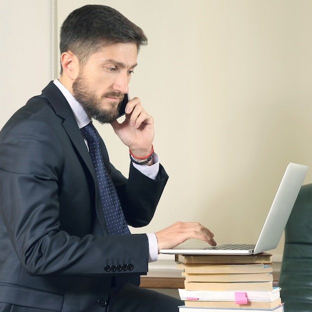 Hombre de negocios exitoso en la oficina trabajando con ordenador portátil