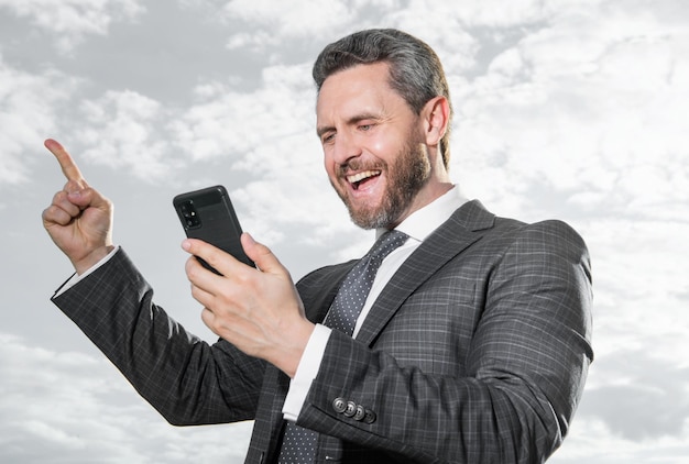 hombre de negocios exitoso tipo mensaje de teléfono usar traje foto de hombre de negocios tipo mensaje de teléfono hombre de negocios tipo mensaje de teléfono en el cielo fondo hombre de negocios tipo mensaje de teléfono al aire libre